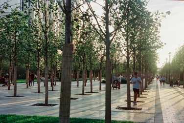 A lively urban park in Astana, Kazakhstan, captured during a sunny day with people enjoying outdoor activities.